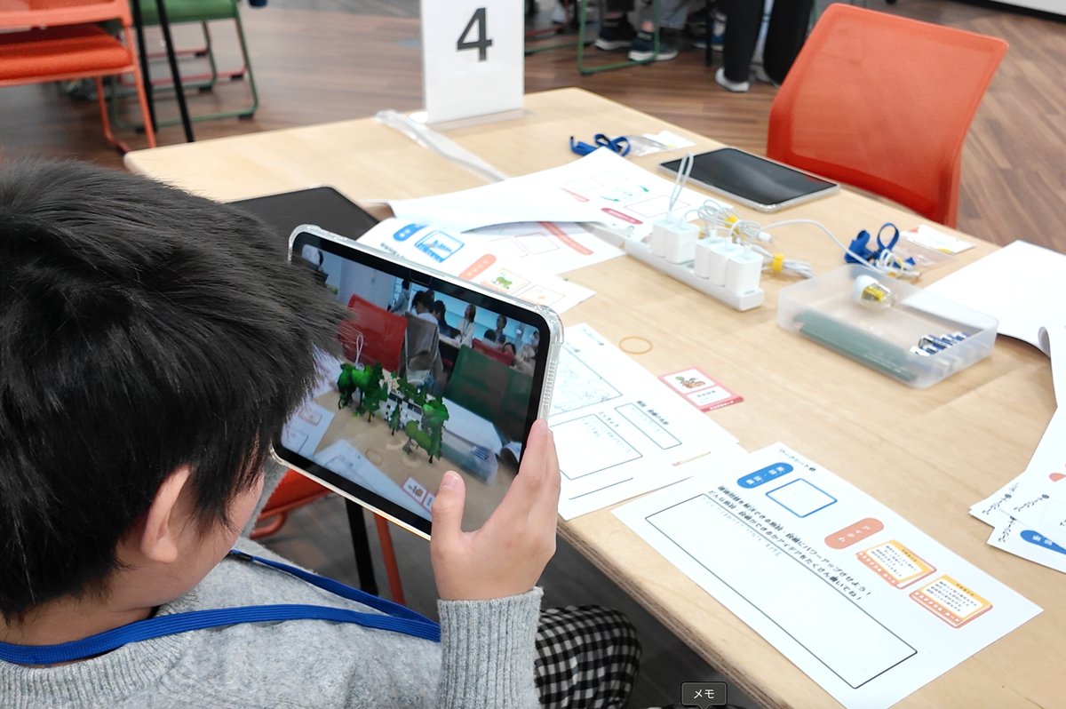 タブレットのARで、つくった作品を目の前の床に映し出している様子