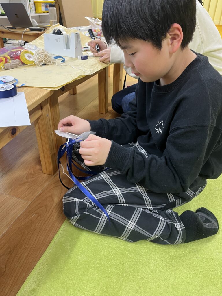 複数のリボンを組み合わせたり調整したりして、手元の細かい作業に集中している様子