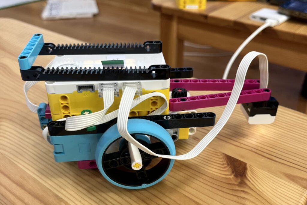 木のテーブルの上に置かれた、レゴ エデュケーション SPIKE プライムで作られた2輪走行型のロボット
