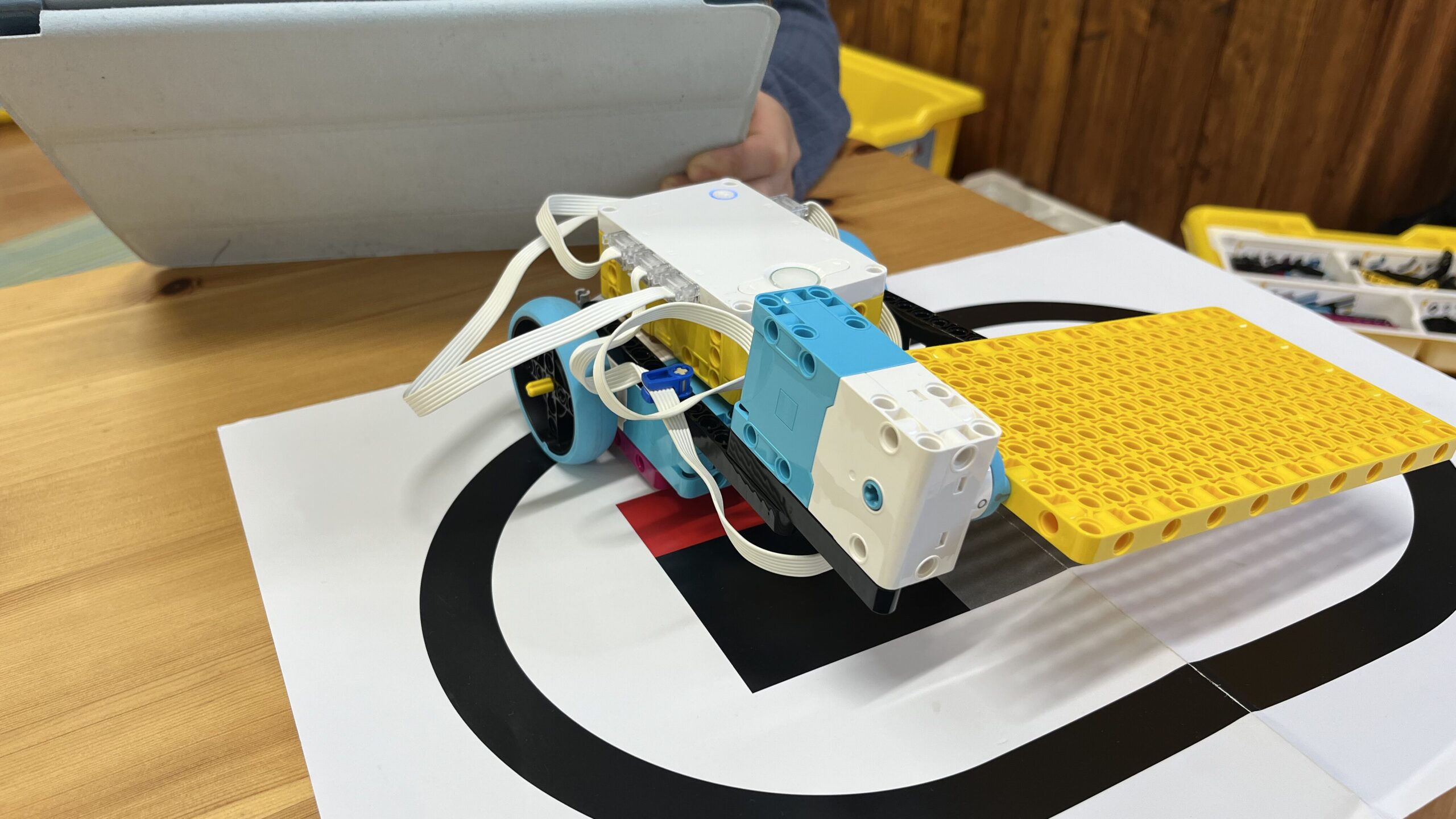 相手を押し出すための黄色い大型パーツを装着し、本番のフィールドで最終調整を行っているロボット