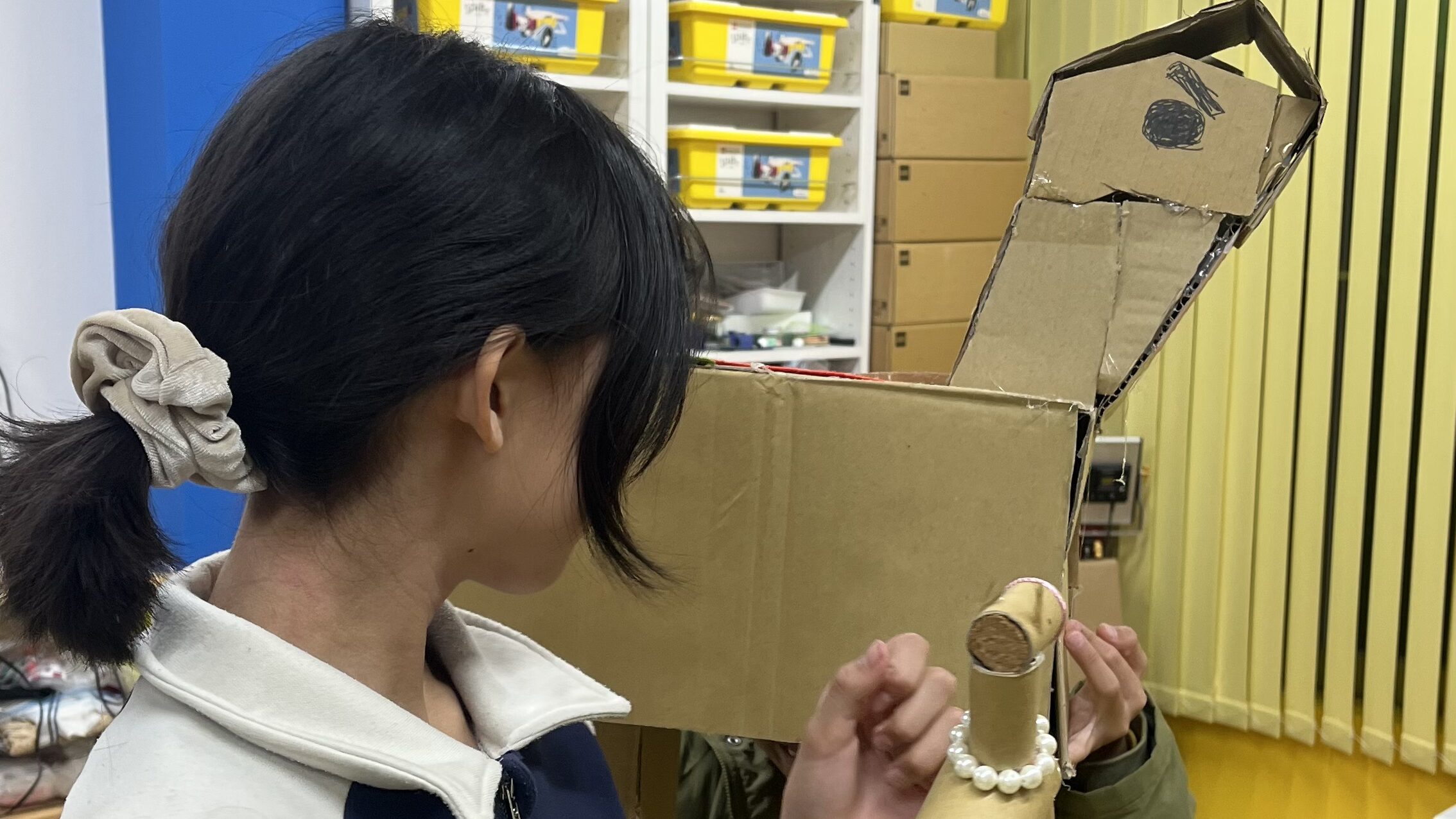 小学生の男の子が段ボールで作った大きな馬と、それに驚いて振り向く小学生の女の子