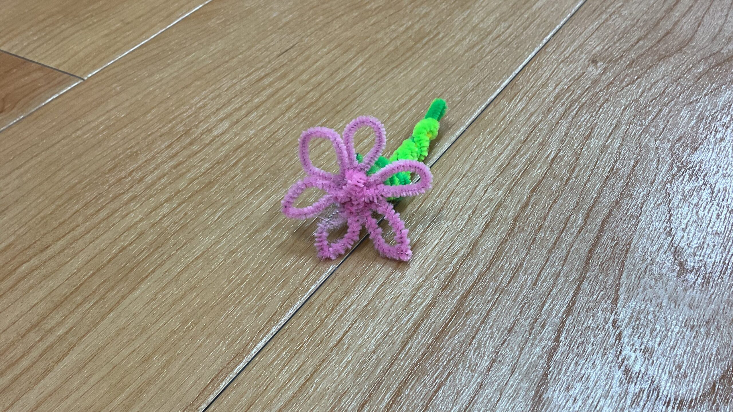 モールで作成されたピンク色の花が床に置かれている。
