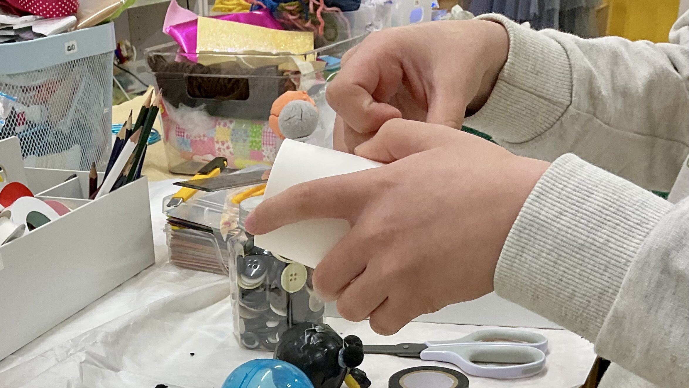 男子小学生が、紙コップにテープを張り付けて工作している。