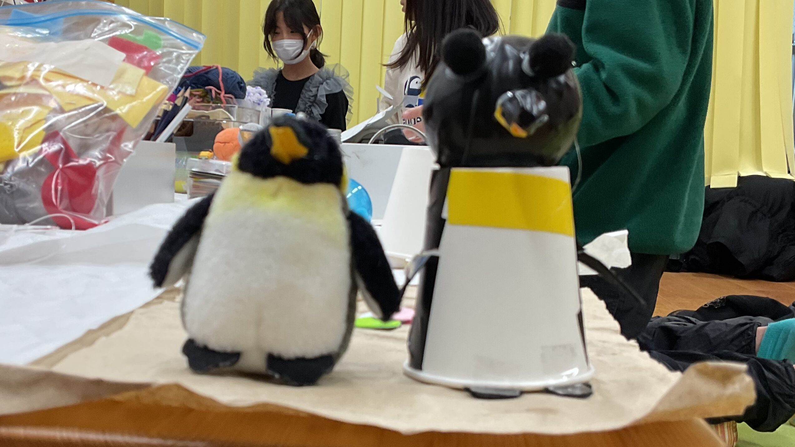 男子小学生が工作したペンギンのマスコットと市販のペンギンのマスコットのツーショット。