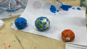 粘土で作った惑星に色を塗った作品例 青い星 地球っぽい星 オレンジの星が並ぶ