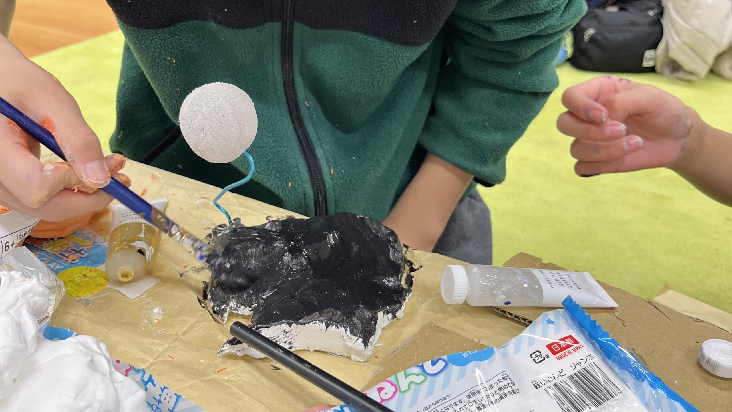子どもが惑星模型に筆で仕上げをしている様子 天地の日の宇宙工作で立体表現を楽しむ（府中のSTEAM工作教室Pendemy）