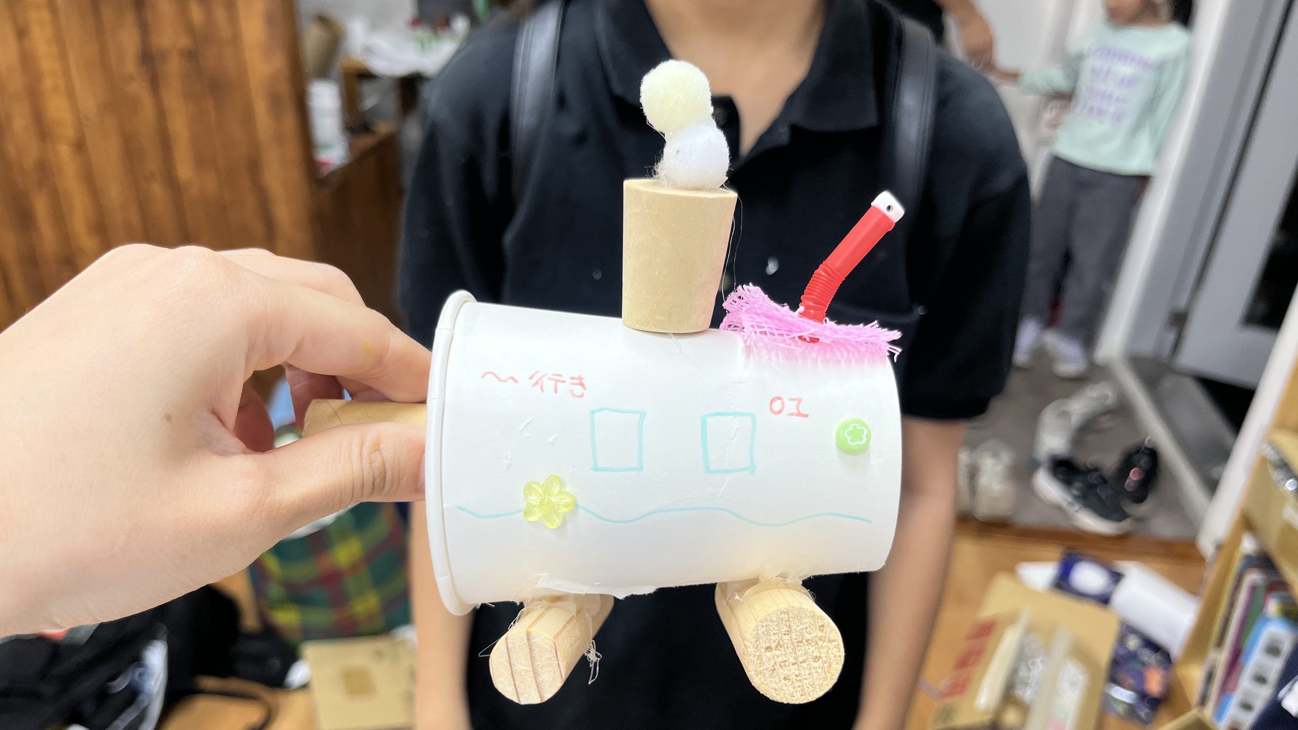 紙コップや木材、ポンポンなど身近な材料を組み合わせて制作した、小学生のオリジナル乗り物工作作品